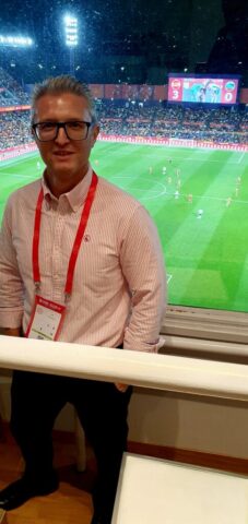 Vesselin Dimitrov - Intérprete Búlgaro-Español: Un Vistazo desde la Cabina del Estadio José Zorrilla (Partido Clasificatorio - Mundial 2026) Dentro de la cabina de megafonía del Estadio José Zorrilla en Valladolid, con el campo de fútbol y el partido entre España y Bulgaria de fondo.